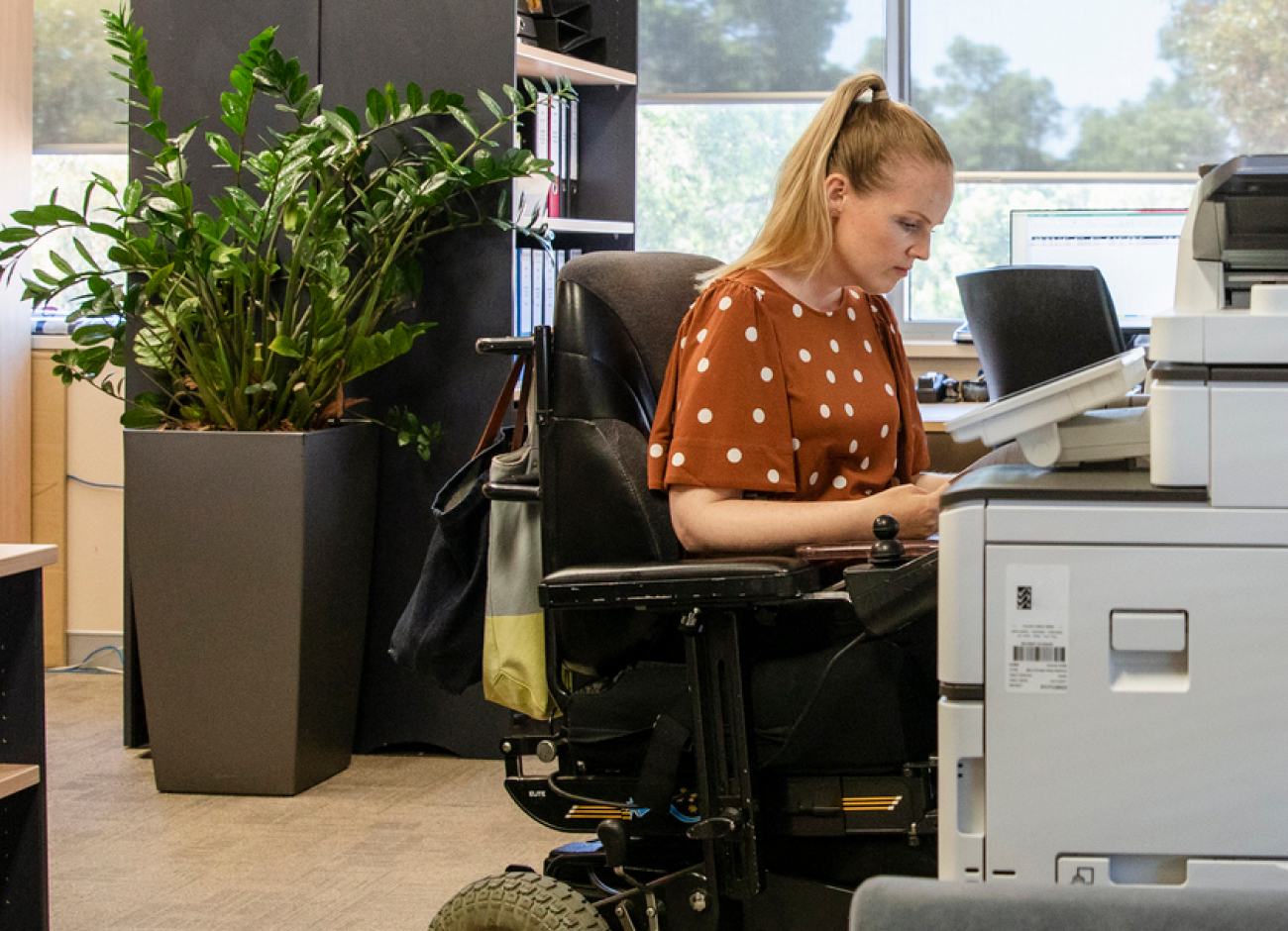 Woman in a wheel chair working in an office.