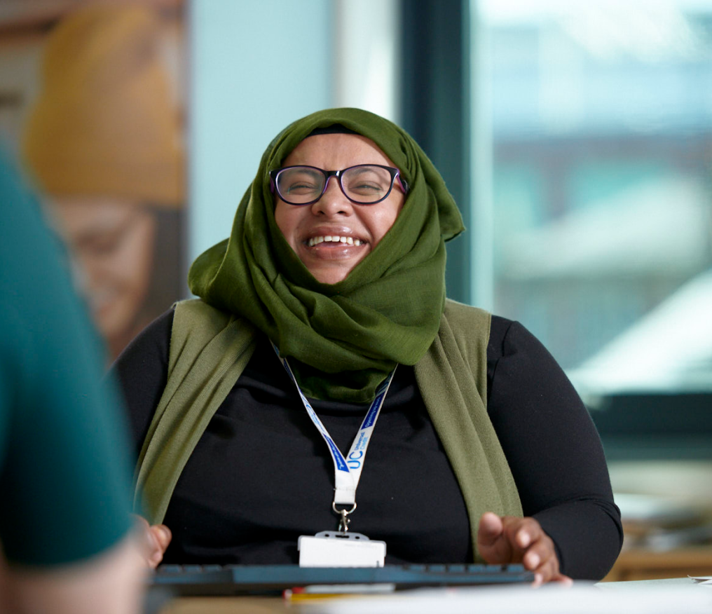 DWP Work Coach in head scarf smiling in Jobcentre Plus