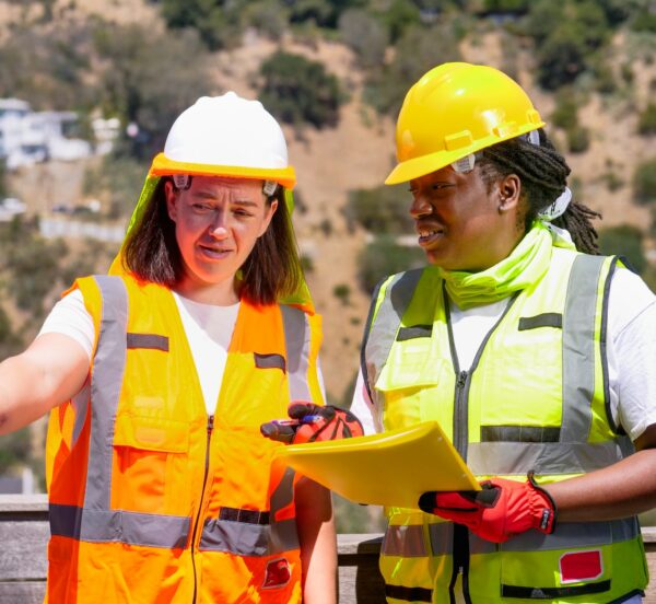 Two women in protective clothing on a buildig site.