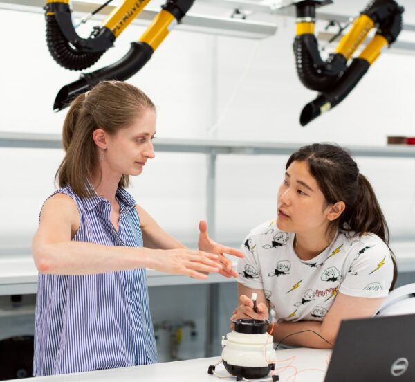 Two women discussing electronics in a laboratory