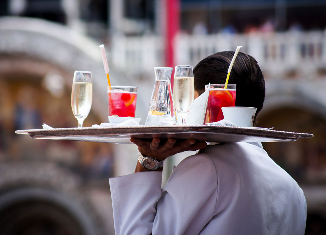 Waiter carrying tray of drinks