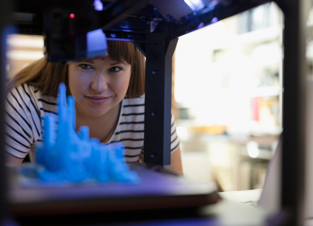 Woman looking at a 3D printer