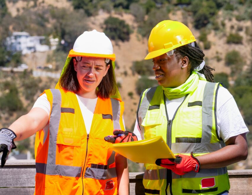 Two women in protective clothing on a buildig site.