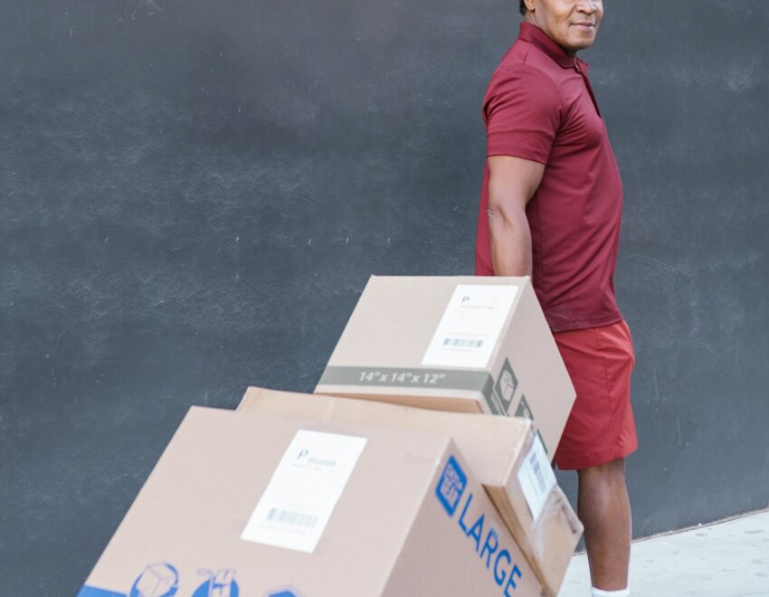 Delivery man moving boxes on parcel truck