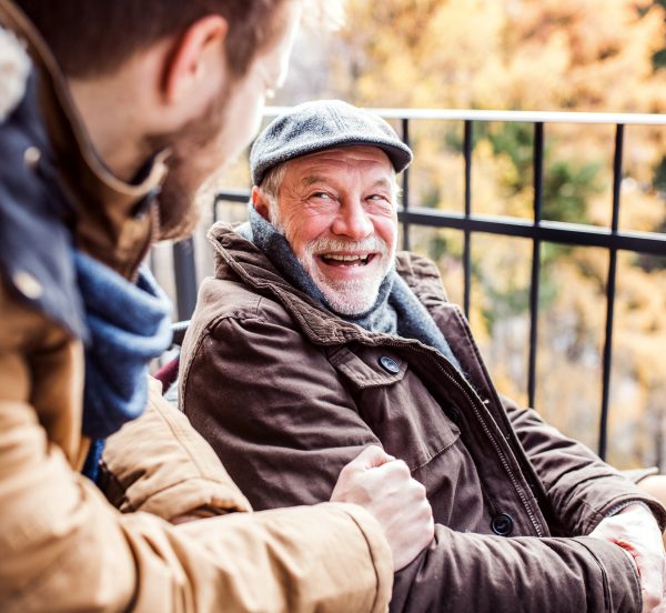 Senior man laughing while talking to a younger man